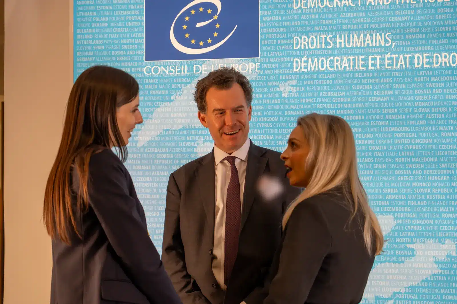Trois participants échangent devant le mur du Conseil de l’Europe à Strasbourg pendant Her Voice Impacts