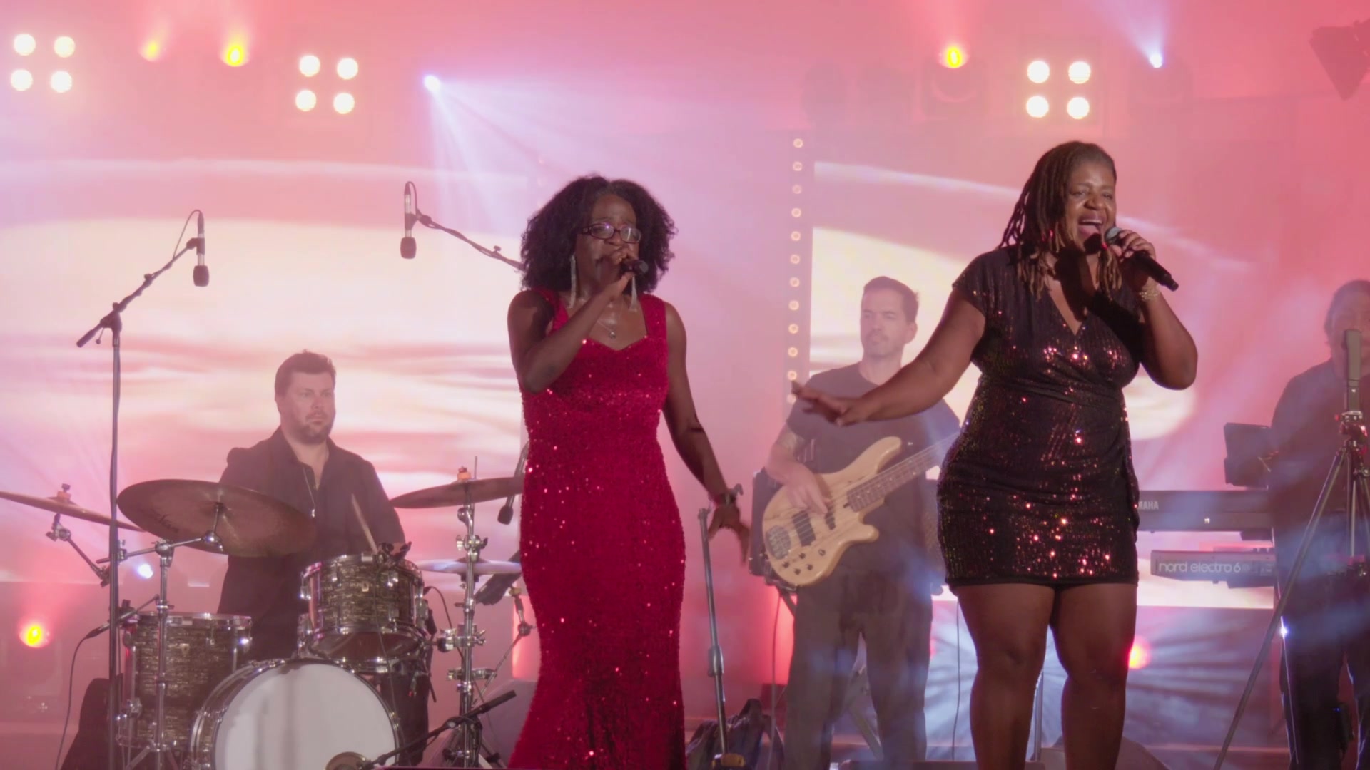 Les deux chanteuses de Moabi Village chantent ensemble sous les projecteurs